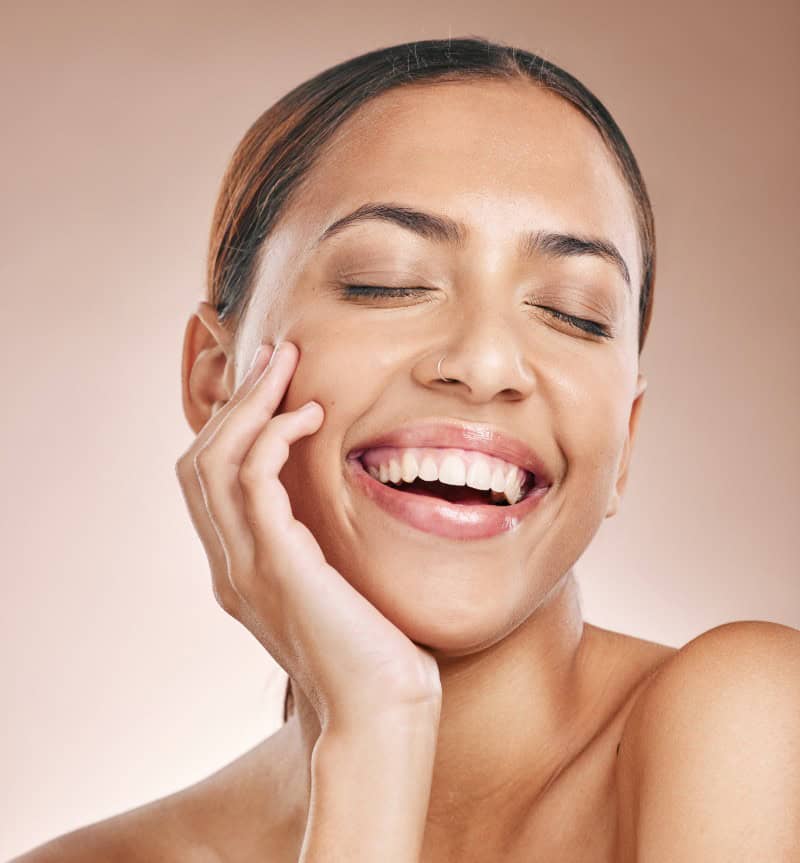 Smiling woman touching her silky skin on studio background.Advertising Polynucleotide treatments at Rathfarnham Medical