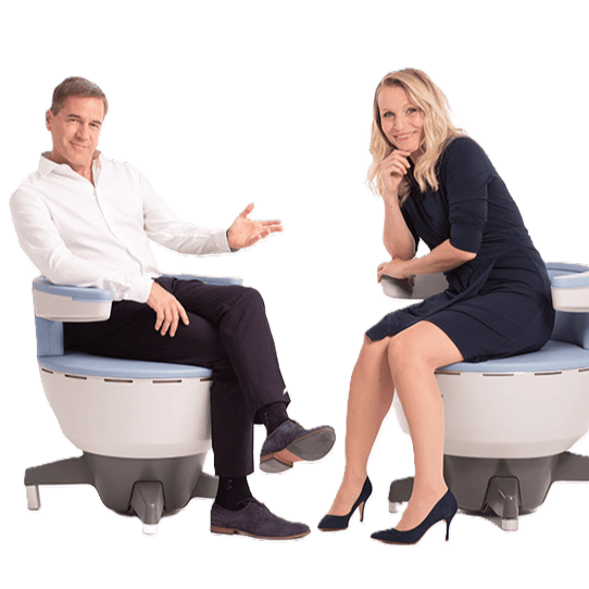 a man and woman sitting on EMSELLA chairs, dressed in business clothes